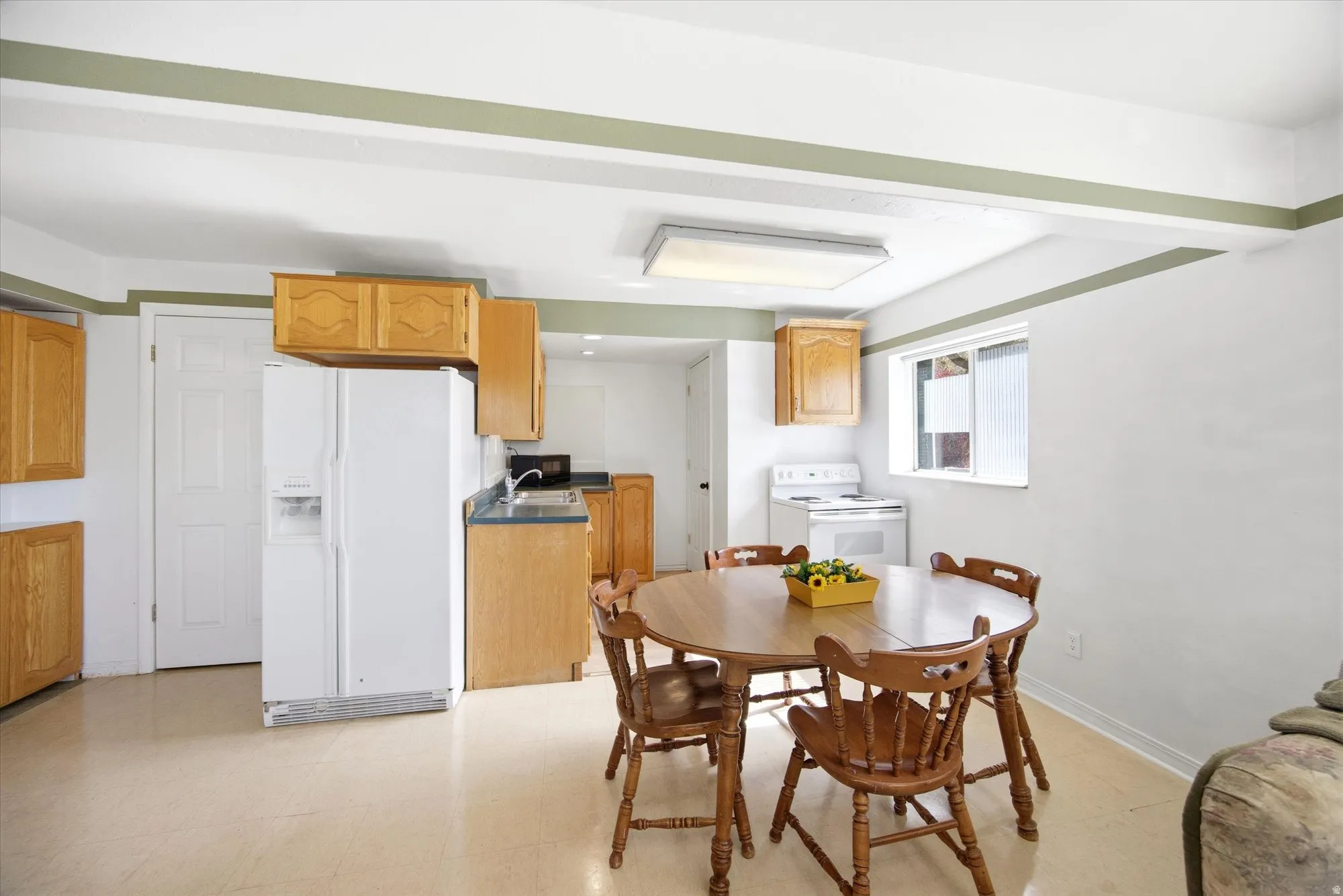 Dining area featuring light floors and baseboards