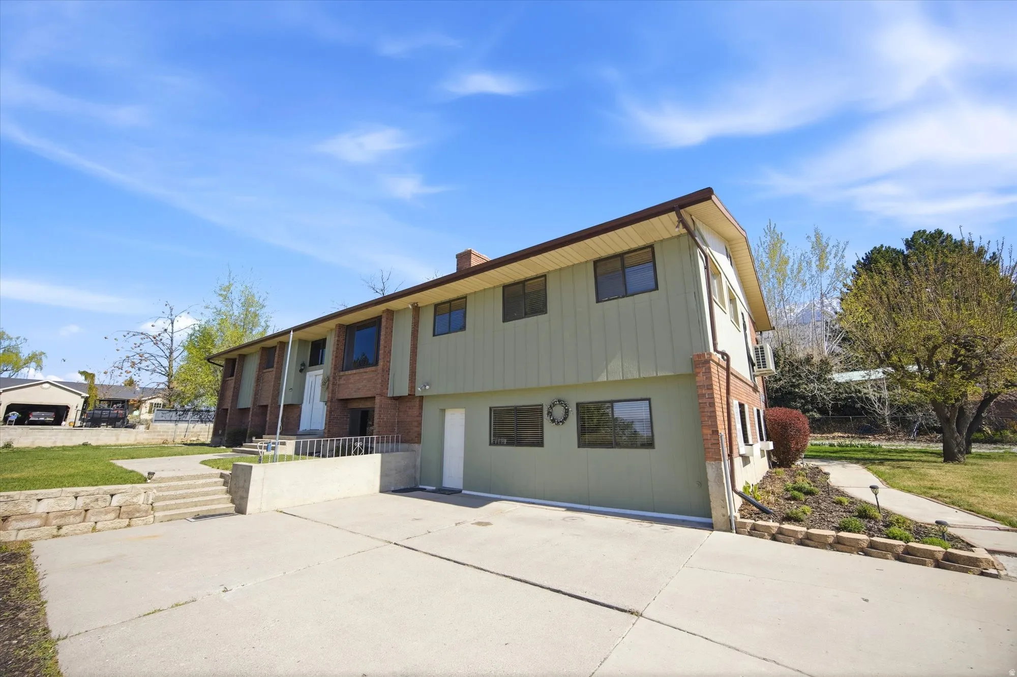 Bi-level home with brick siding, a patio area, and a chimney