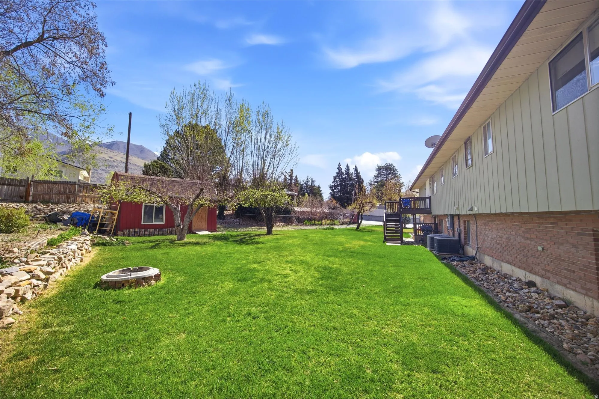 Fenced backyard with a fire pit and an outbuilding