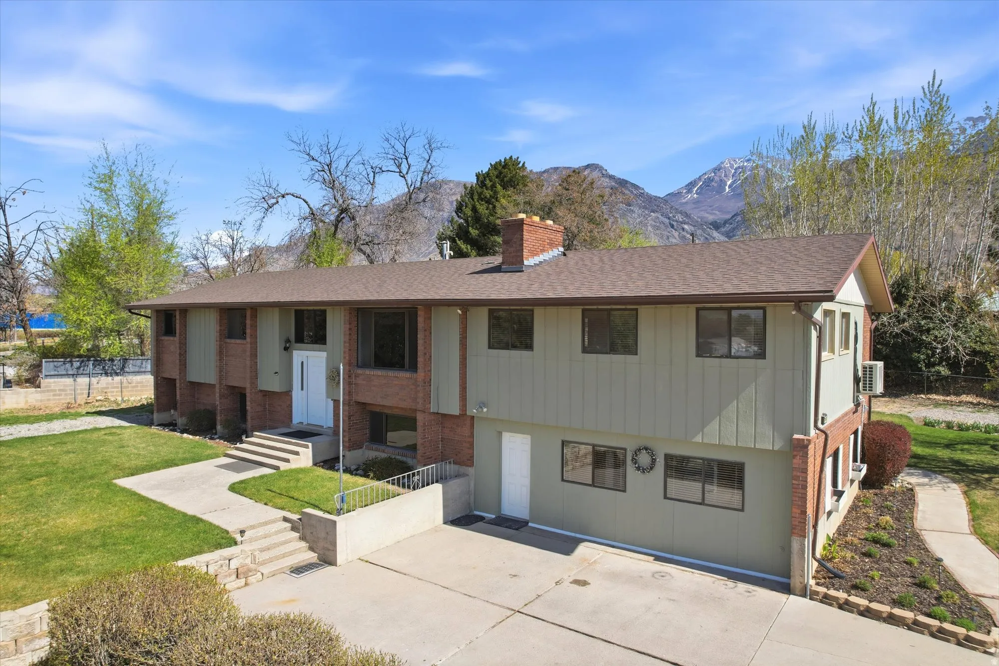 View of front of house with brick siding, a chimney, and a mountain view