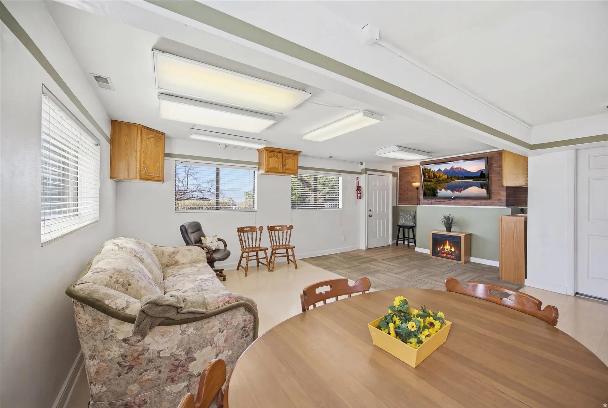 Dining room with a warm lit fireplace and parquet flooring