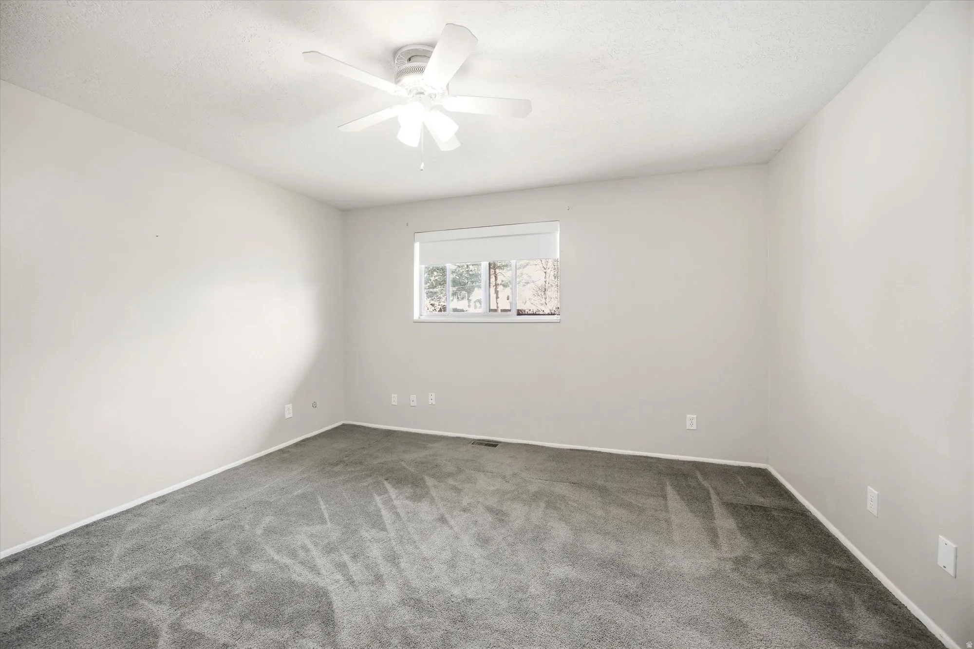 Empty room featuring carpet and ceiling fan