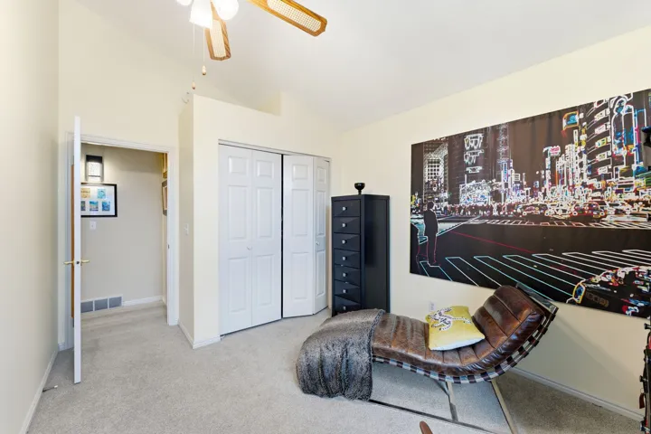Living area with vaulted ceiling, carpet floors, and a ceiling fan