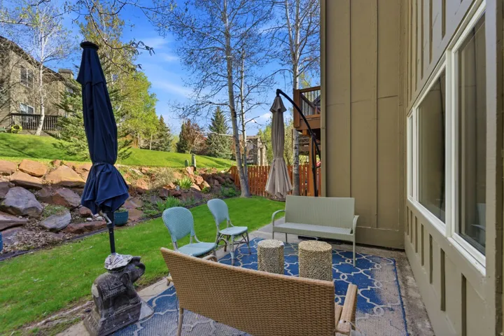 Exterior patio featuring a blue patterned outdoor rug and solid exterior wall paneling