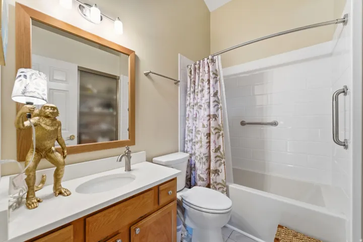 Bathroom featuring vanity and shower / bathtub combination with curtain