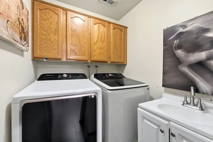 Laundry room featuring cabinet space, washer and dryer, and a textured ceiling