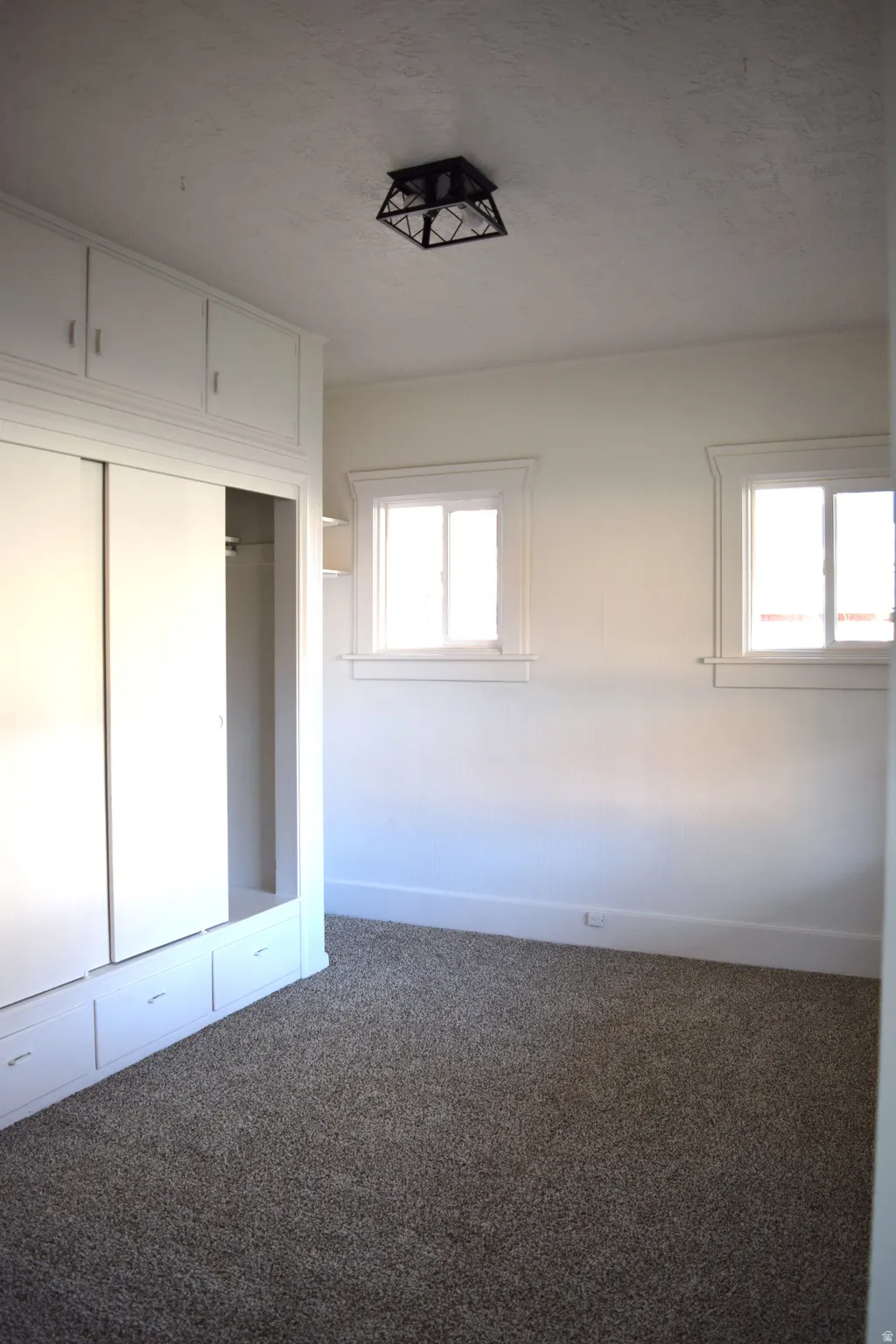 Unfurnished bedroom featuring a closet, carpet, and a textured ceiling