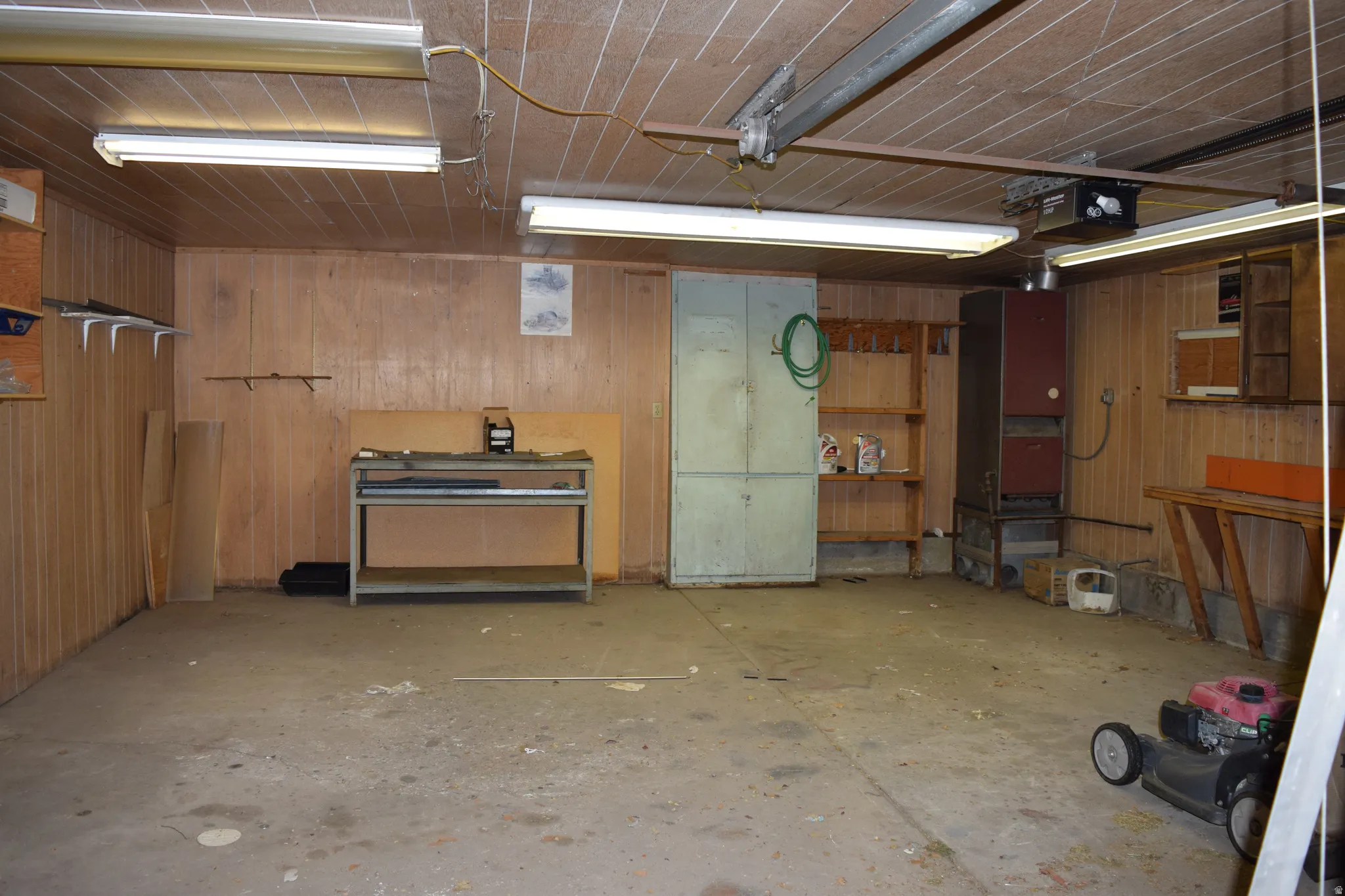 Garage featuring wood walls and a garage door opener
