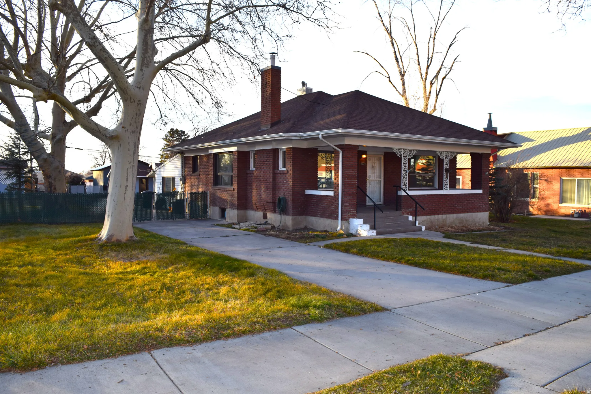 Bungalow-style home featuring a chimney and brick siding