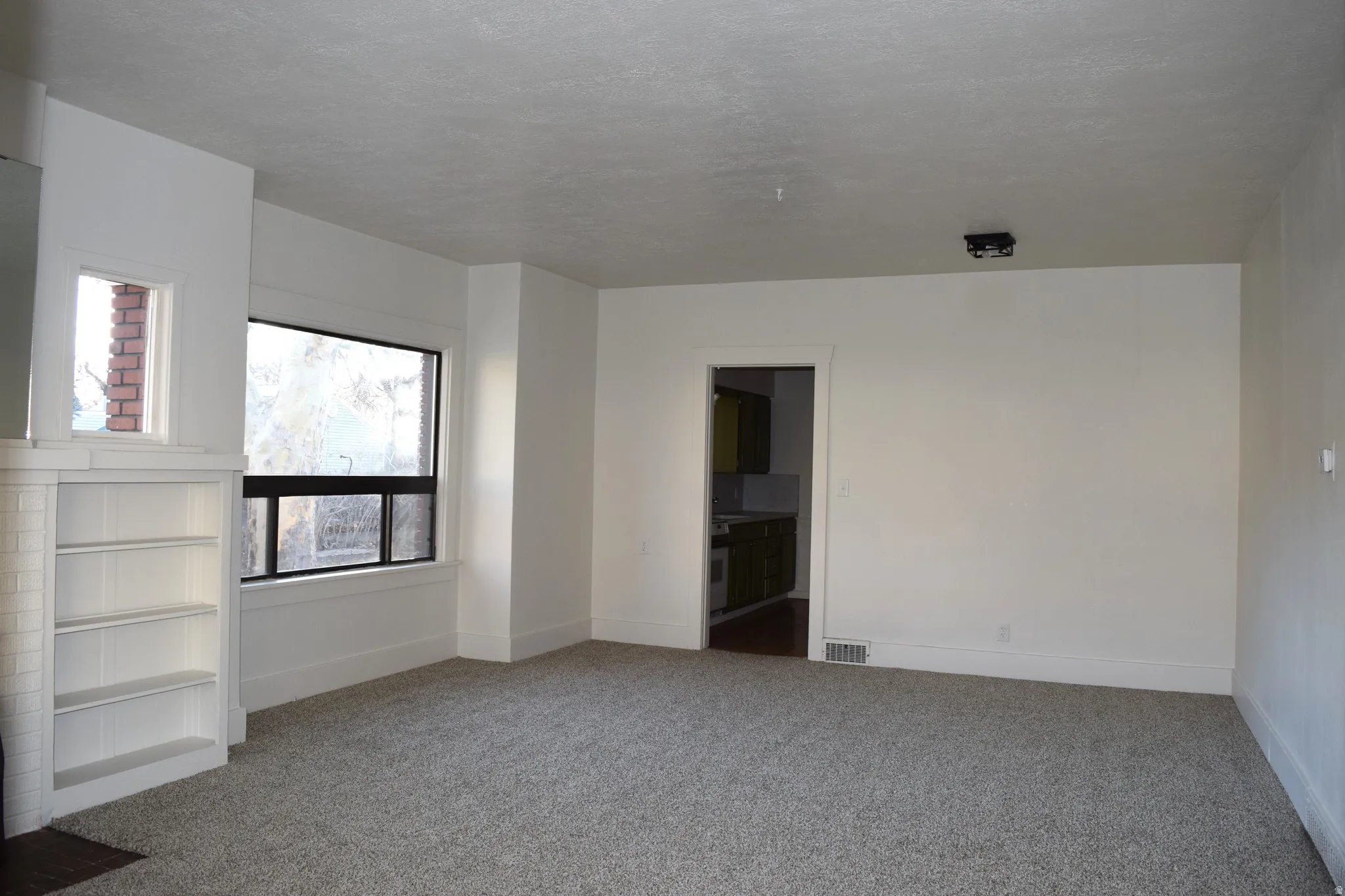 Empty room featuring light colored carpet and baseboards