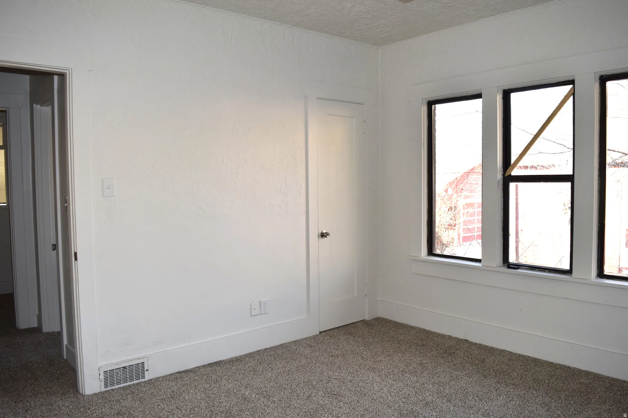 Unfurnished room with carpet and a textured ceiling