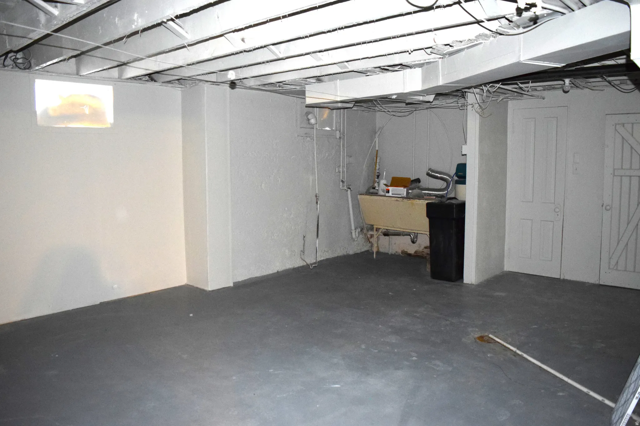 Below grade area featuring a water softener and a sink
