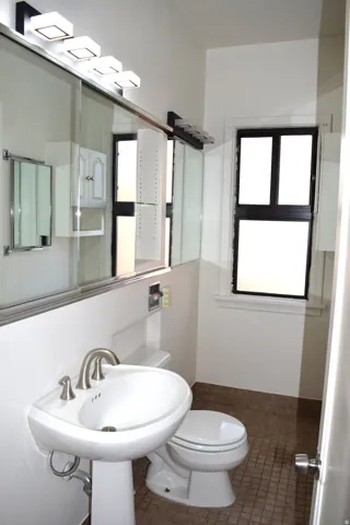 Half bath with toilet and tile patterned floors