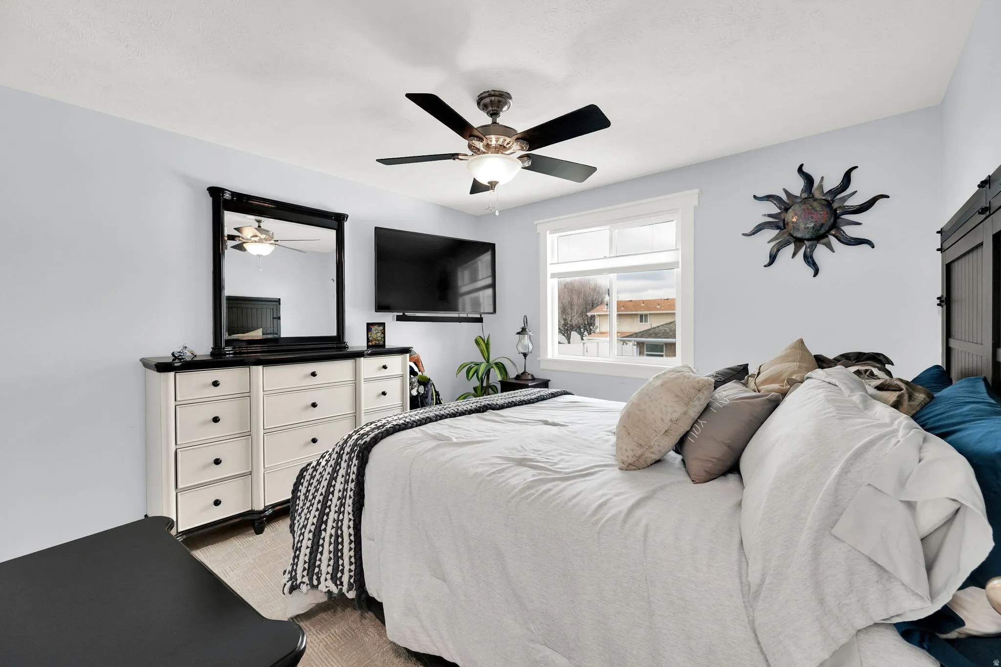 Bedroom featuring a barn door and a ceiling fan
