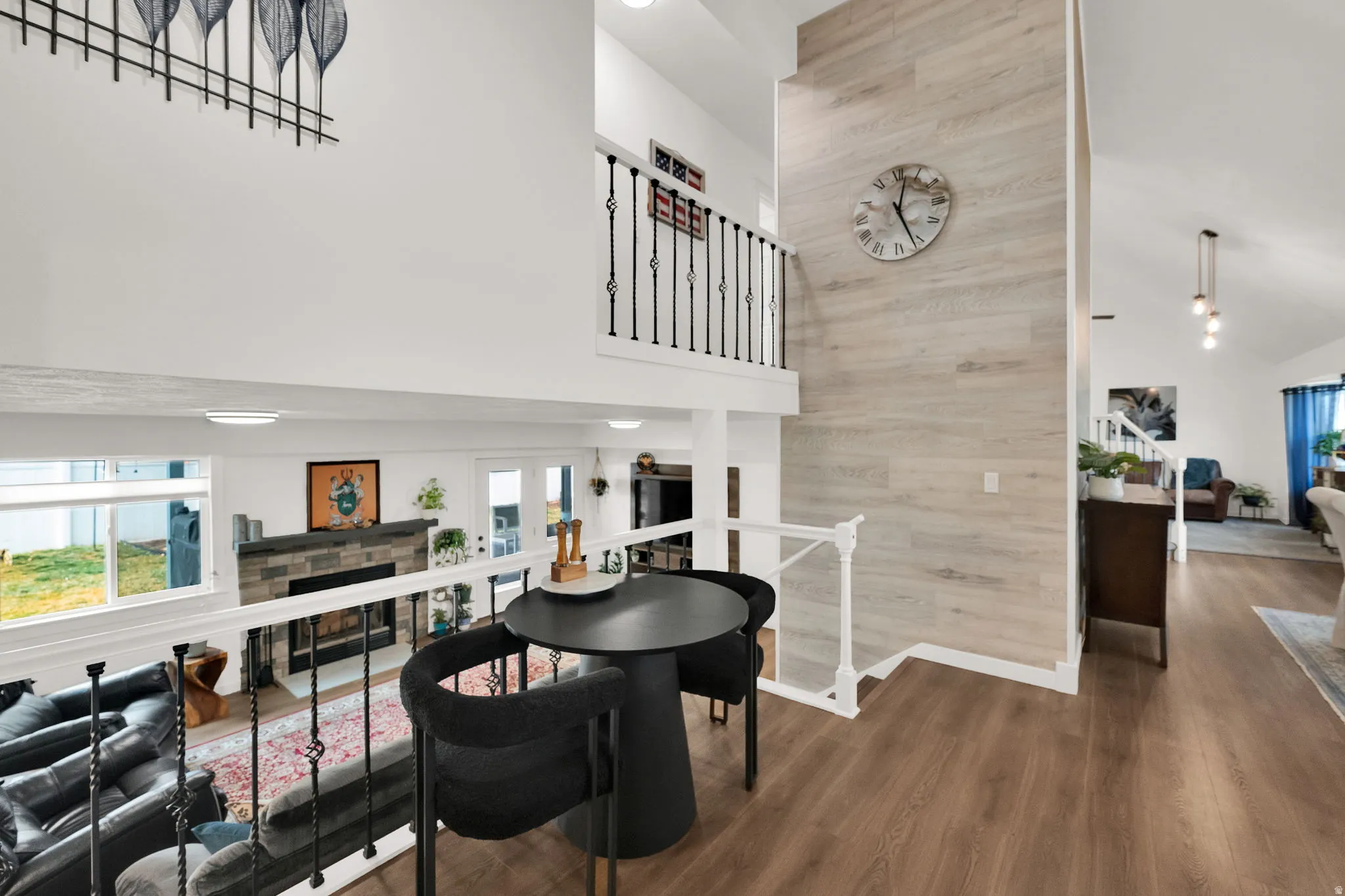 Dining space with a stone fireplace, wood finished floors, vaulted ceiling, and wooden walls