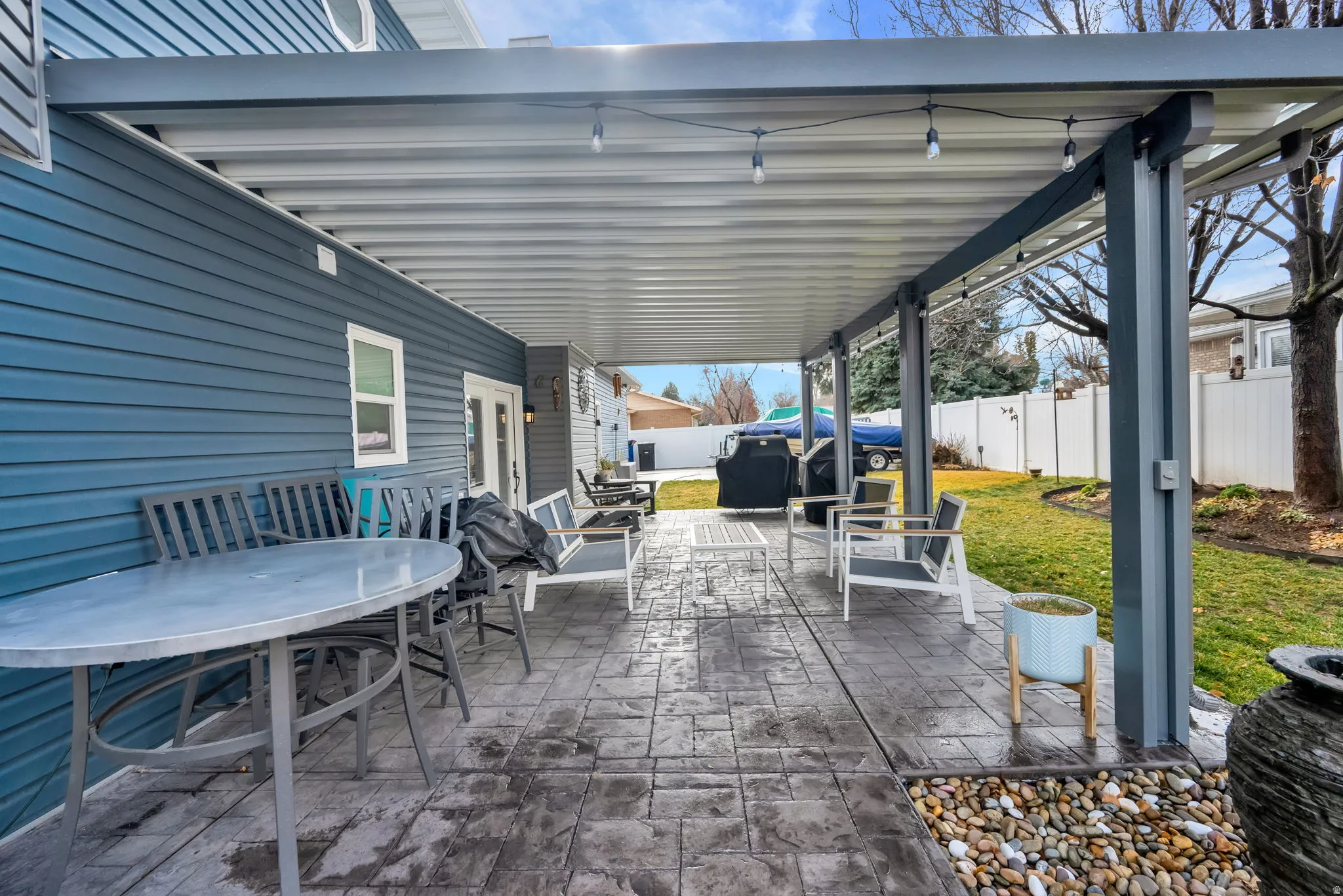 Fenced backyard featuring a patio, outdoor dining space, and grilling area