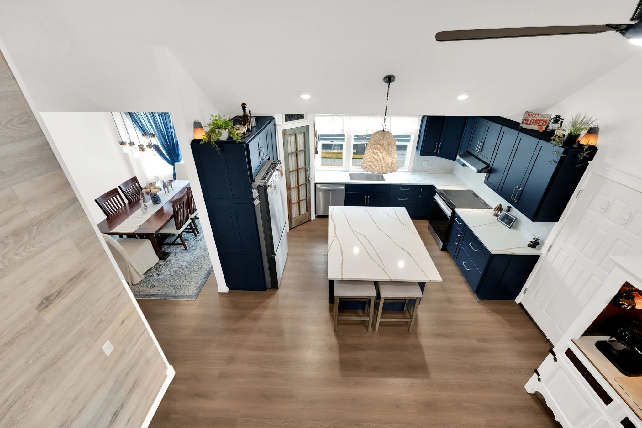 Kitchen featuring blue cabinetry, light countertops, and dark wood-style floors
