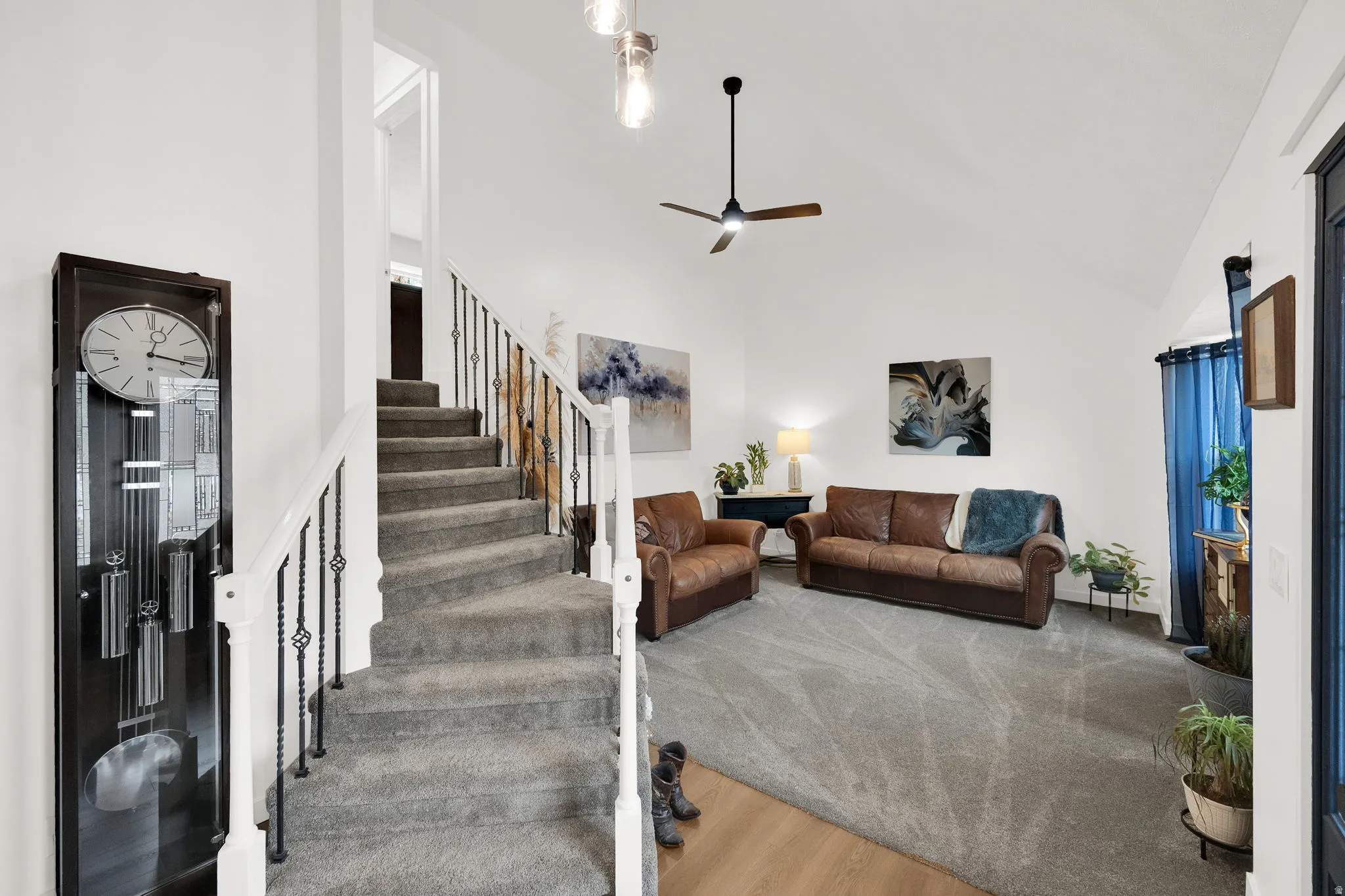 Living area featuring wood finished floors, a ceiling fan, and vaulted ceiling
