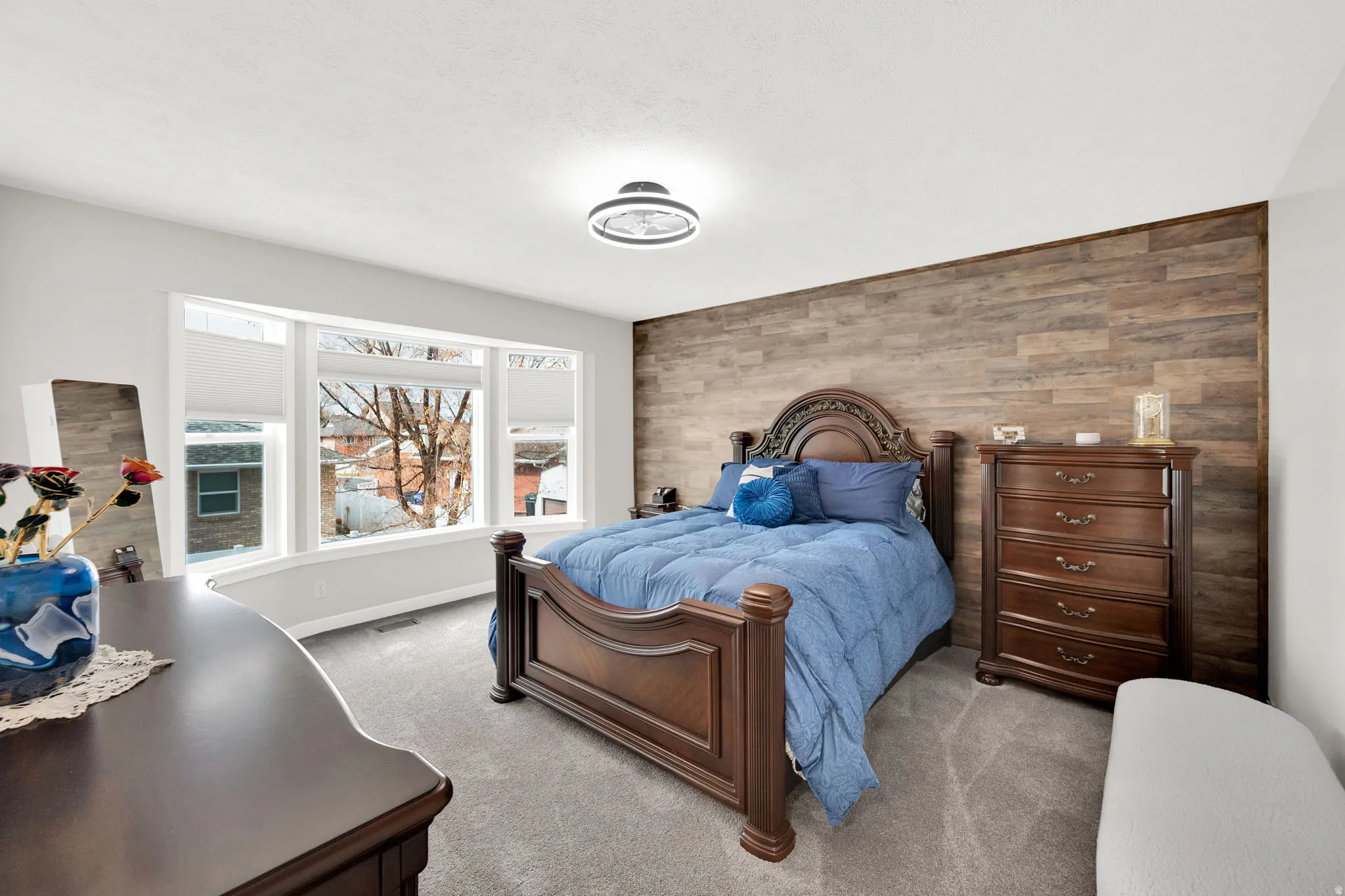 Bedroom with an accent wall, wood walls, and carpet flooring