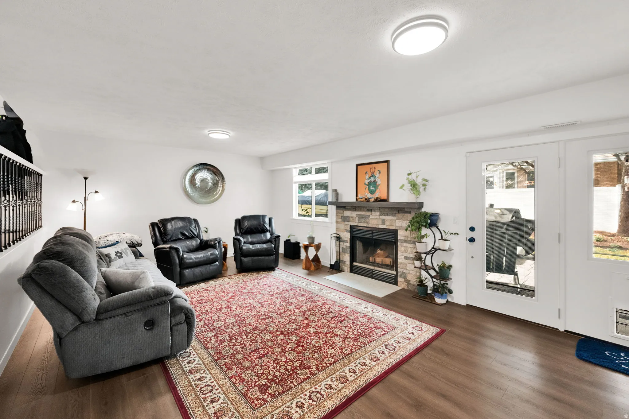 Living area with dark wood-style flooring and a stone fireplace