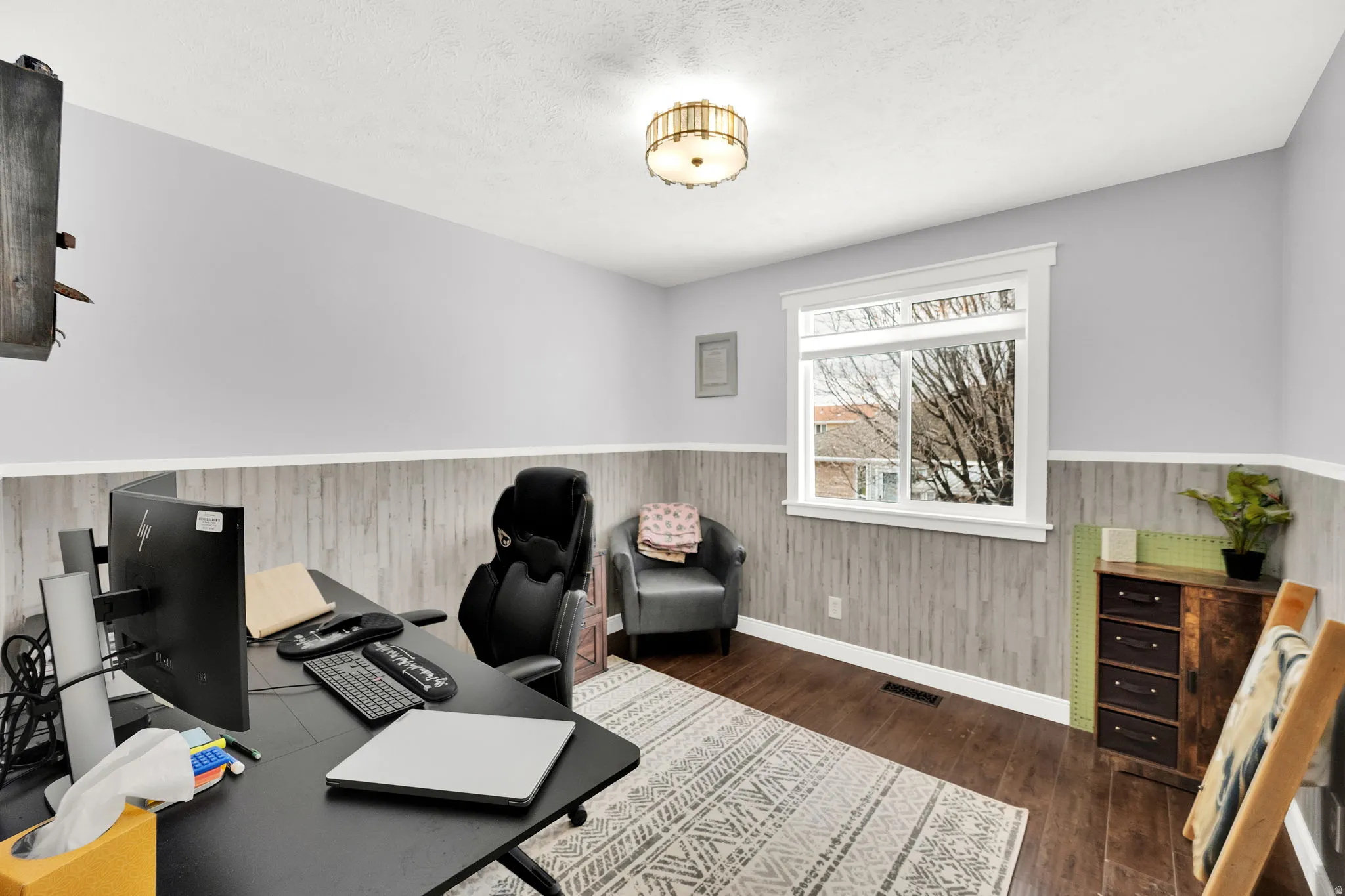 Office area featuring wainscoting and dark wood-style flooring