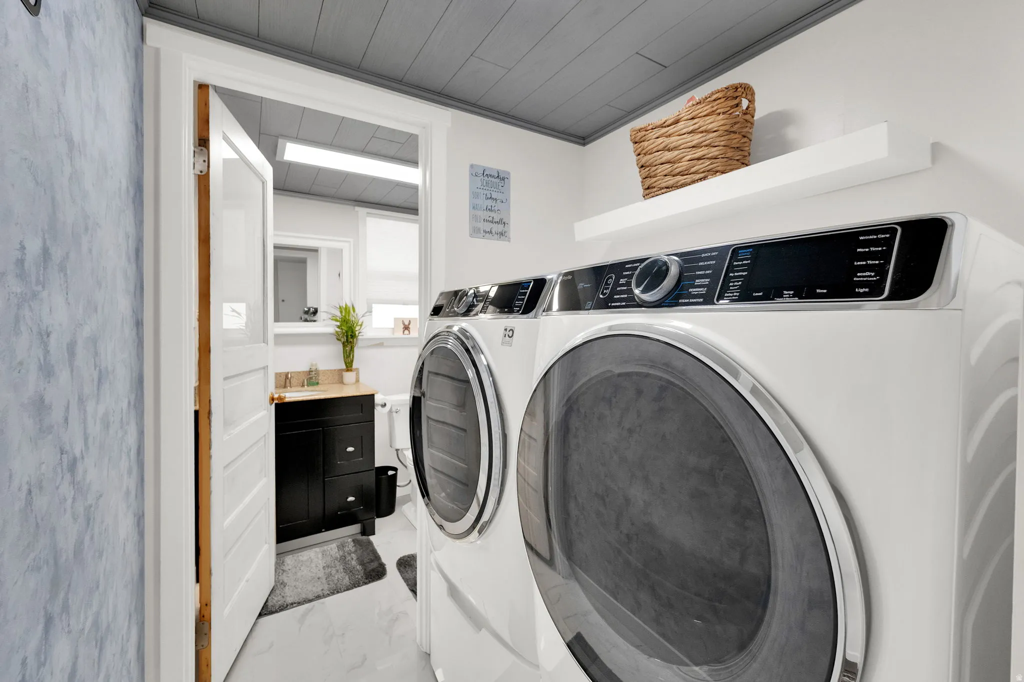 Laundry area with washing machine and clothes dryer and wooden ceiling