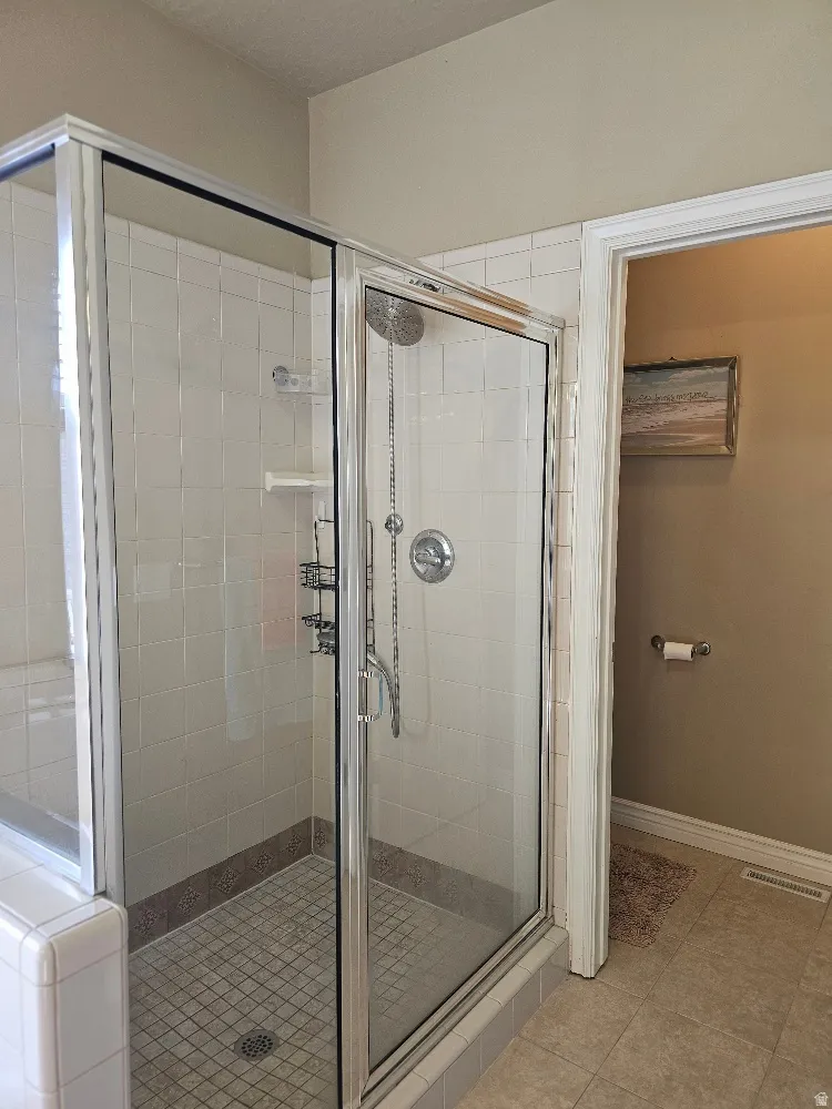 Full bathroom with a stall shower and light tile patterned flooring