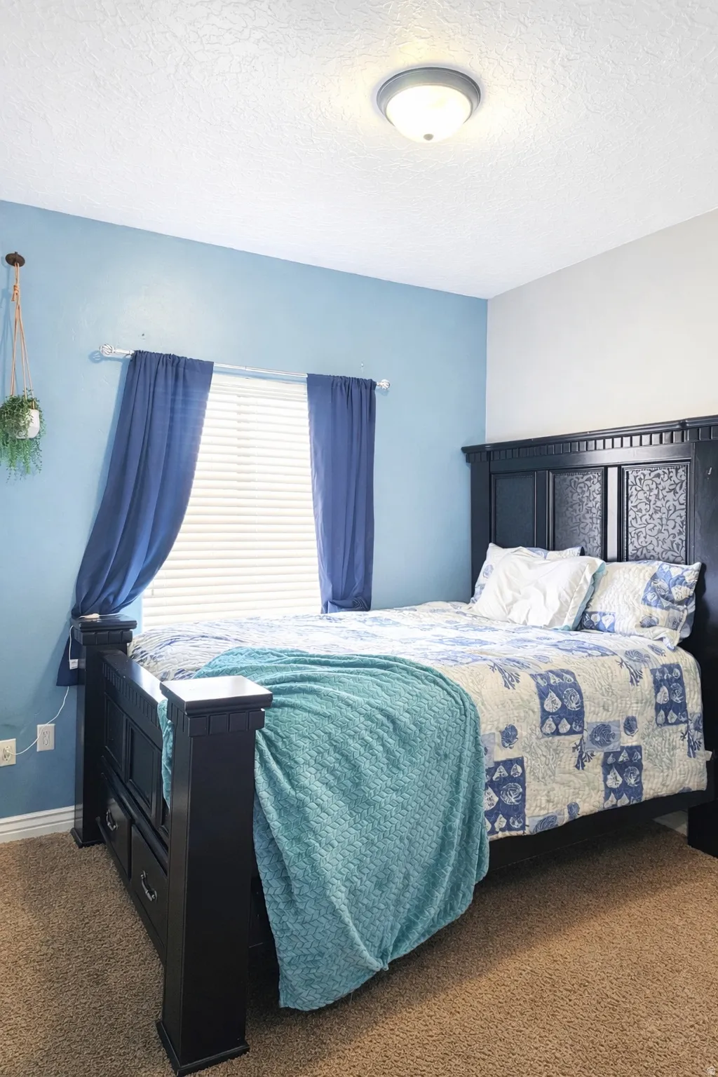 Bedroom featuring carpet flooring and a textured ceiling