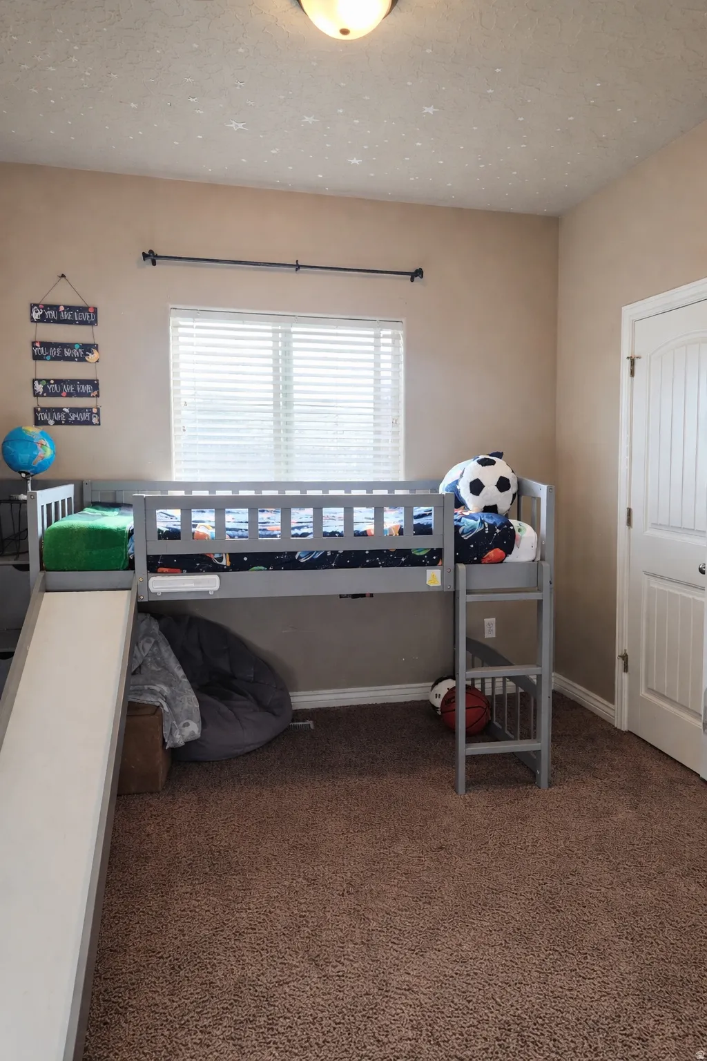 Carpeted bedroom featuring a textured ceiling