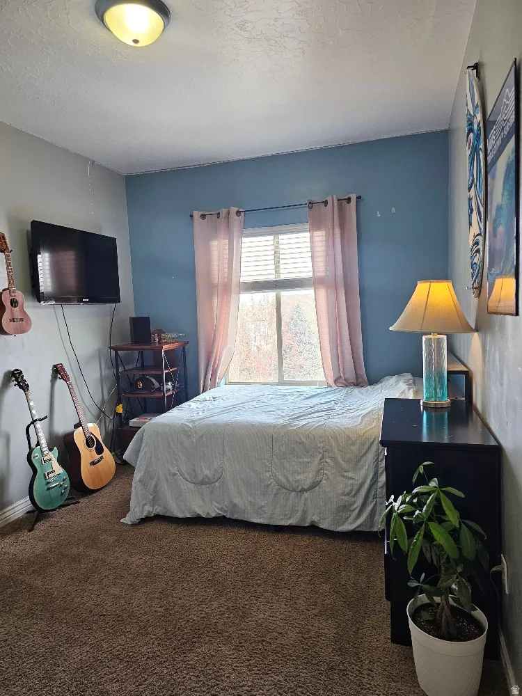 Bedroom featuring carpet and a textured ceiling