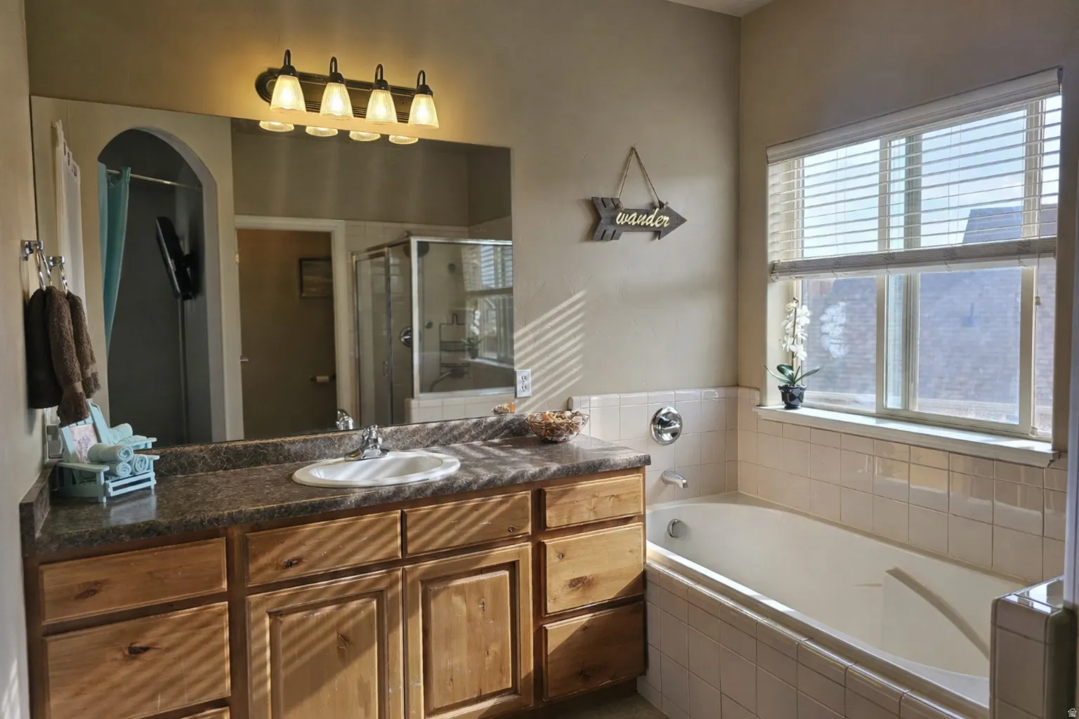 Bathroom featuring a stall shower, vanity, and a garden tub