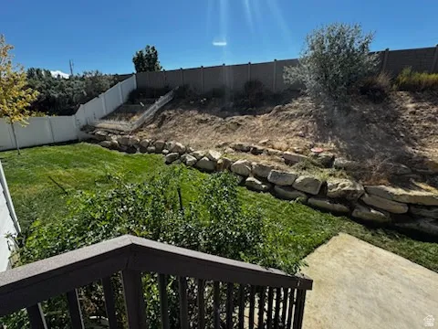 Fenced backyard with a balcony