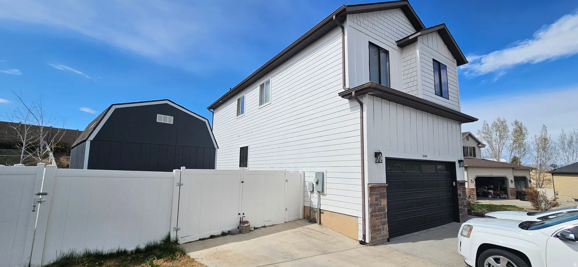 View of home's exterior featuring a gate, an attached garage, and driveway