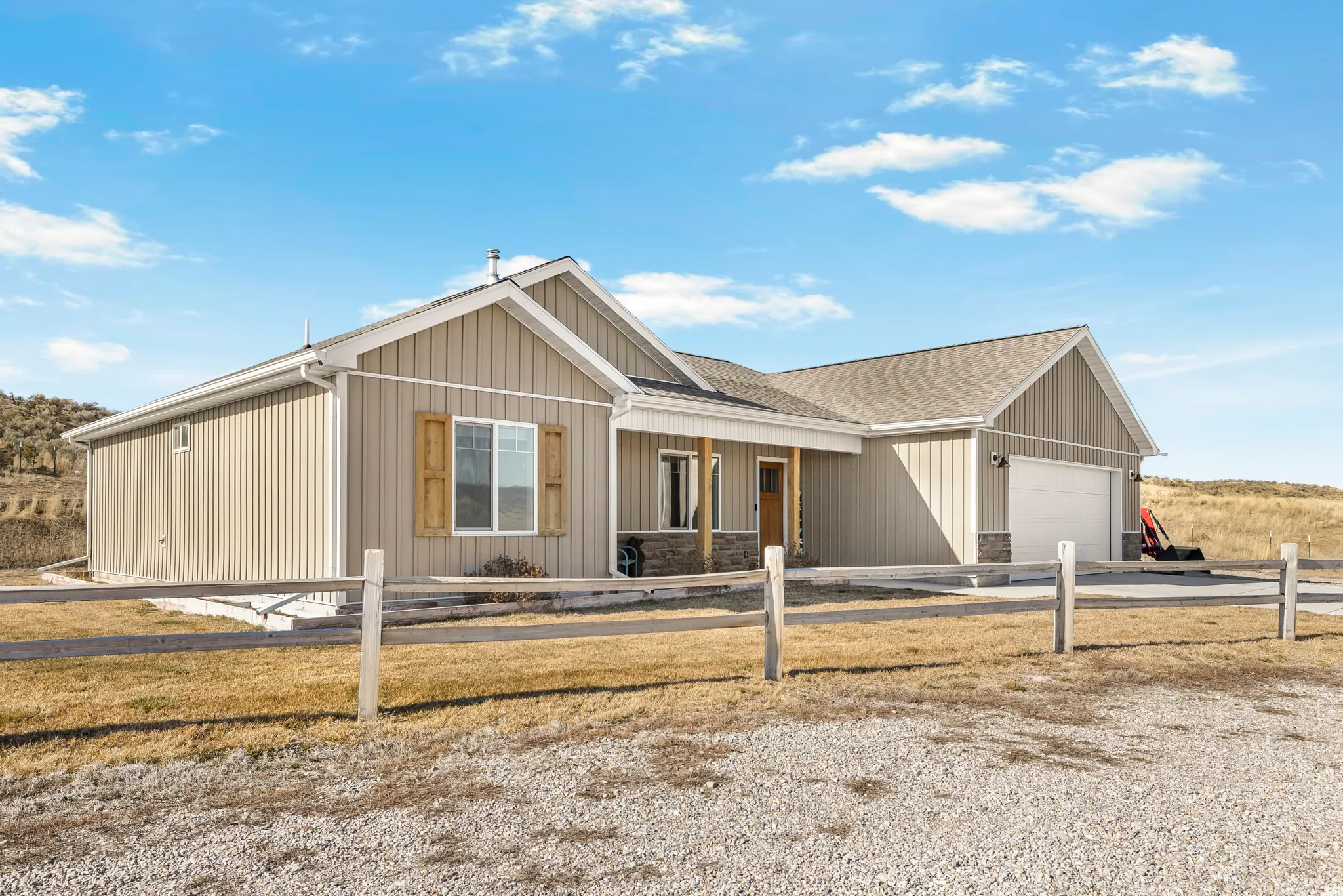 View of front of property with a porch, concrete driveway, a garage, and a fenced front yard