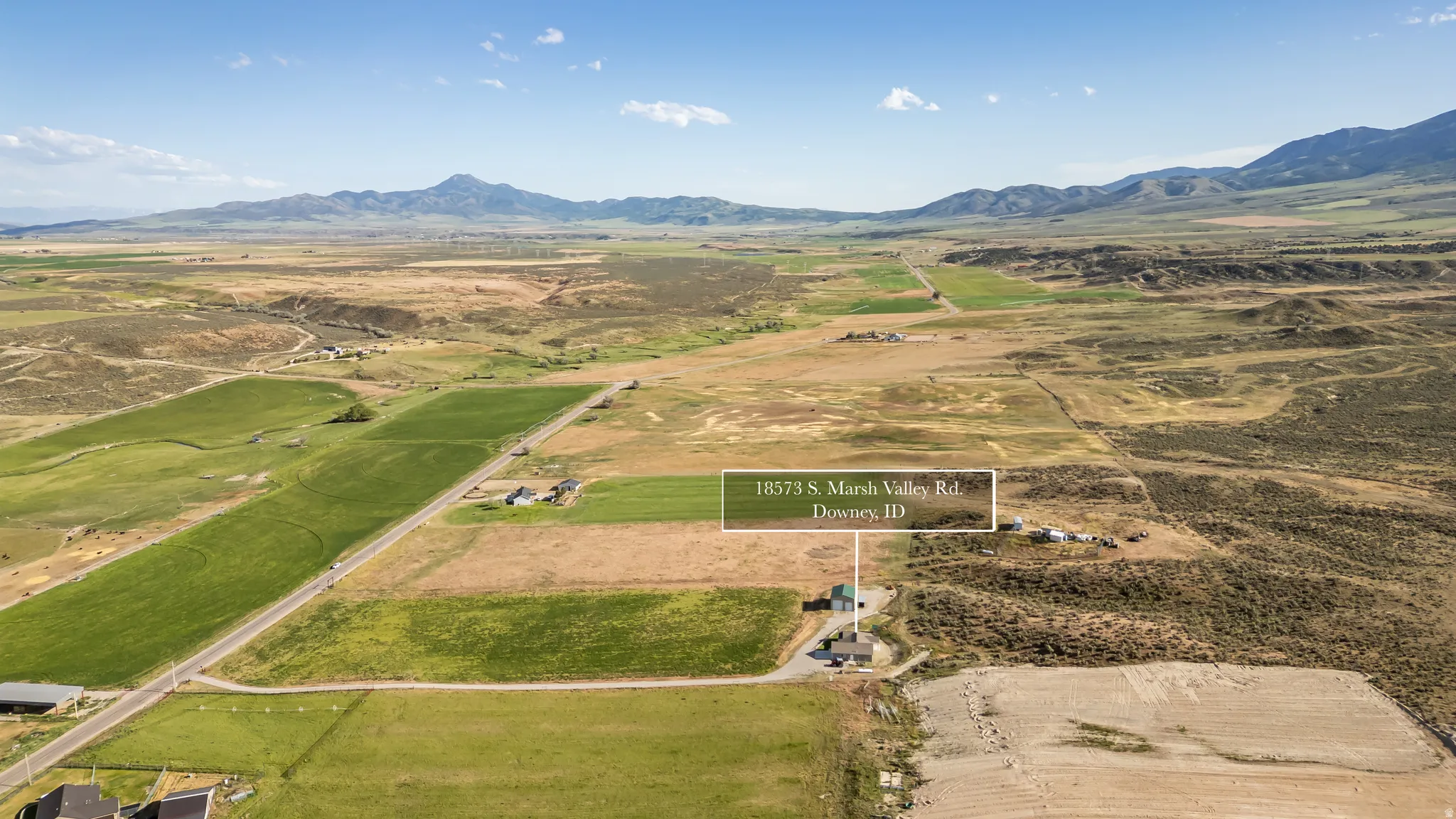 Expansive rural property featuring a primary residence, multiple outbuildings, and cultivated fields