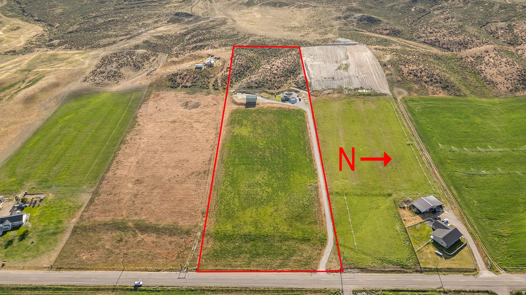Expansive aerial view of a rectangular land parcel outlined in red