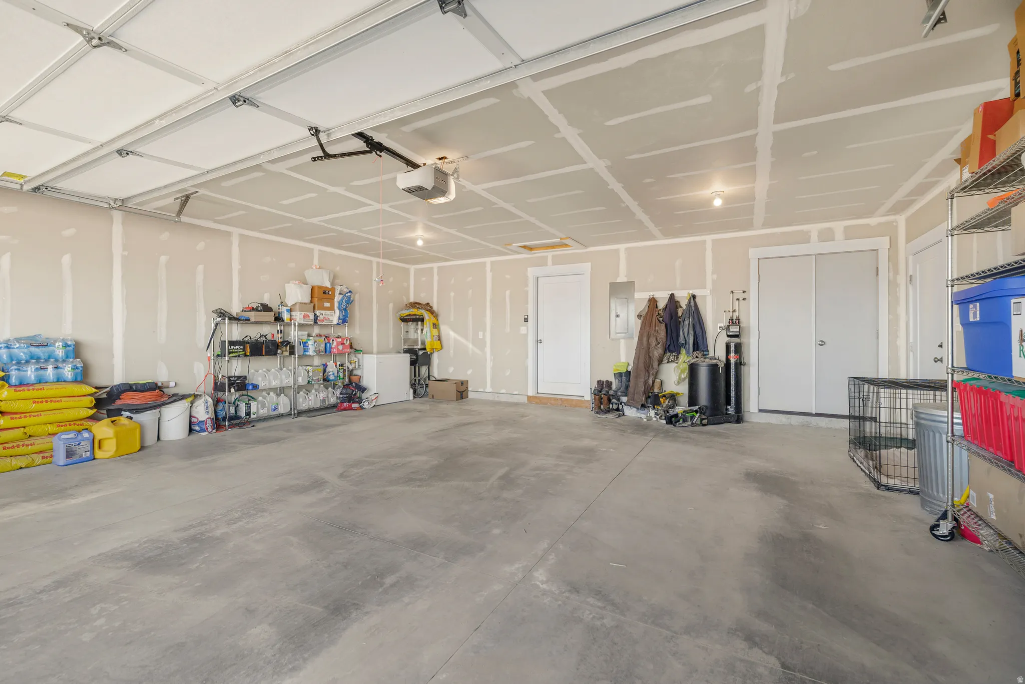 Garage featuring electric panel and a garage door opener