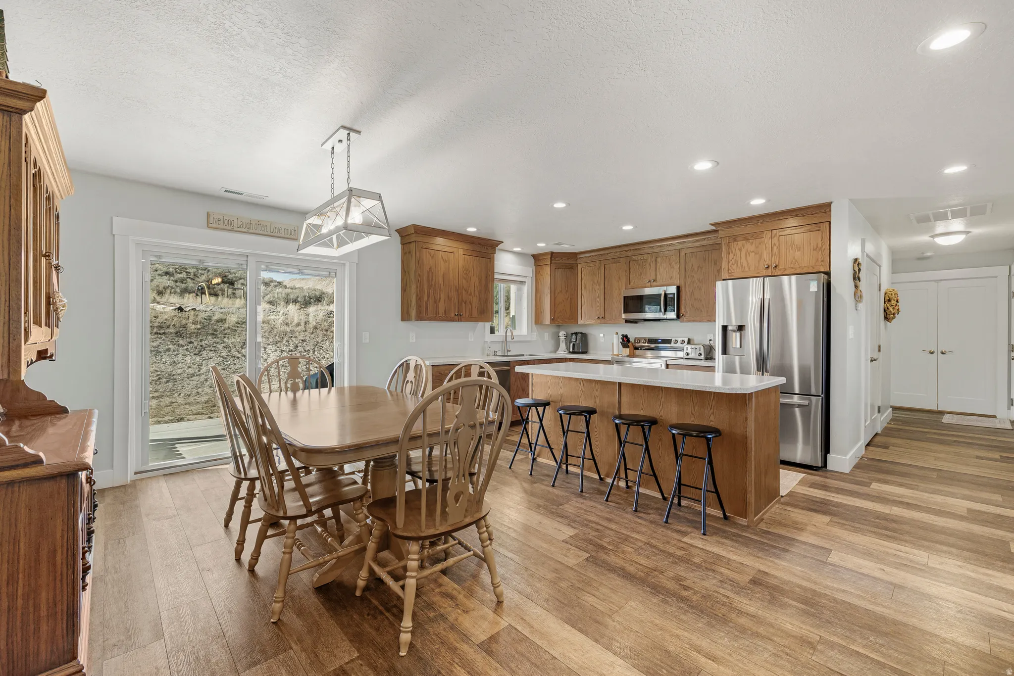 Dining space featuring light wood finished floors, recessed lighting, and a textured ceiling