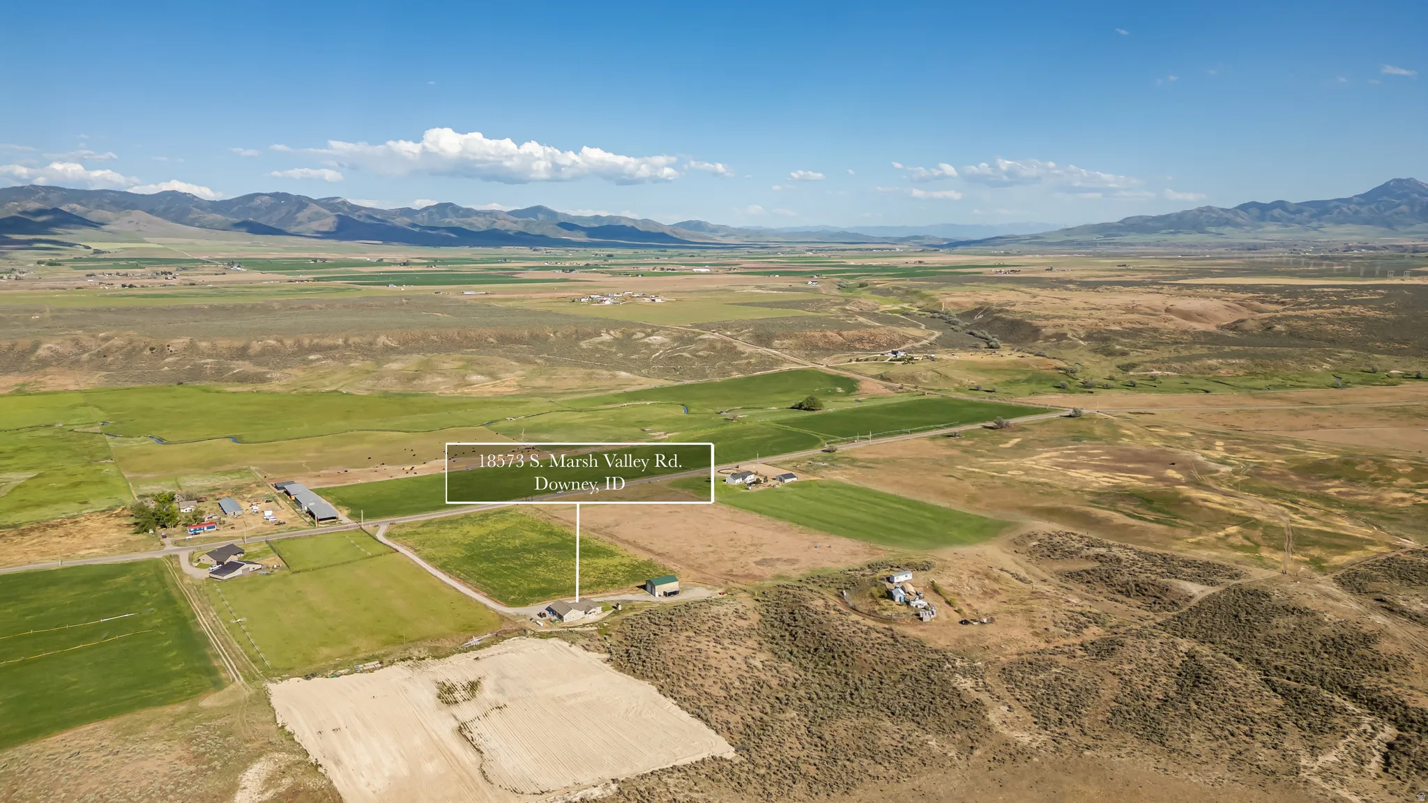 Expansive agricultural landscape featuring various fields and distant mountains
