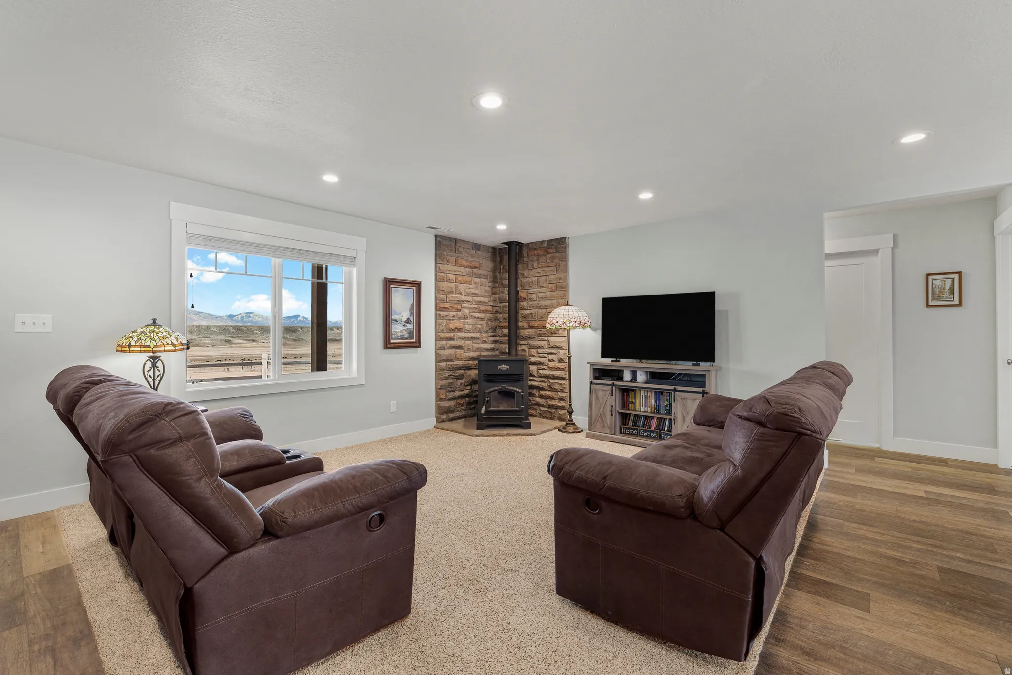 Living area with a wood stove, wood finished floors, and recessed lighting
