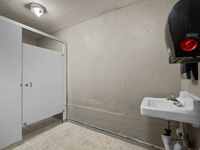 Bathroom featuring a textured wall and a textured ceiling