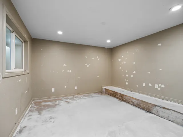 Empty room featuring unfinished concrete flooring