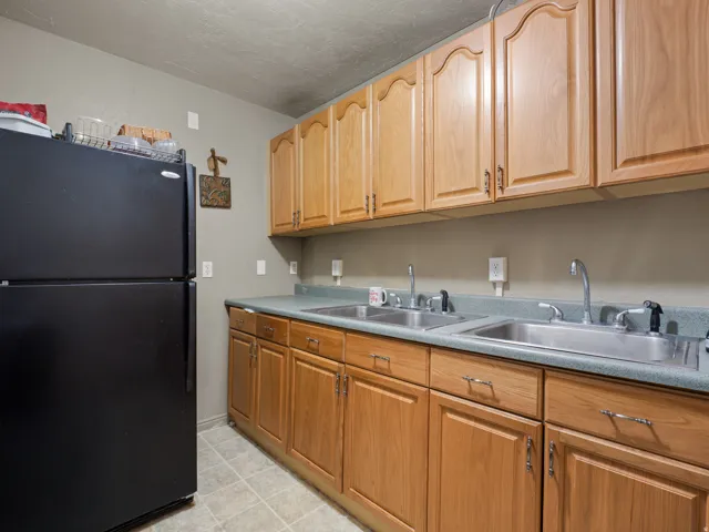Kitchen featuring freestanding refrigerator and light countertops