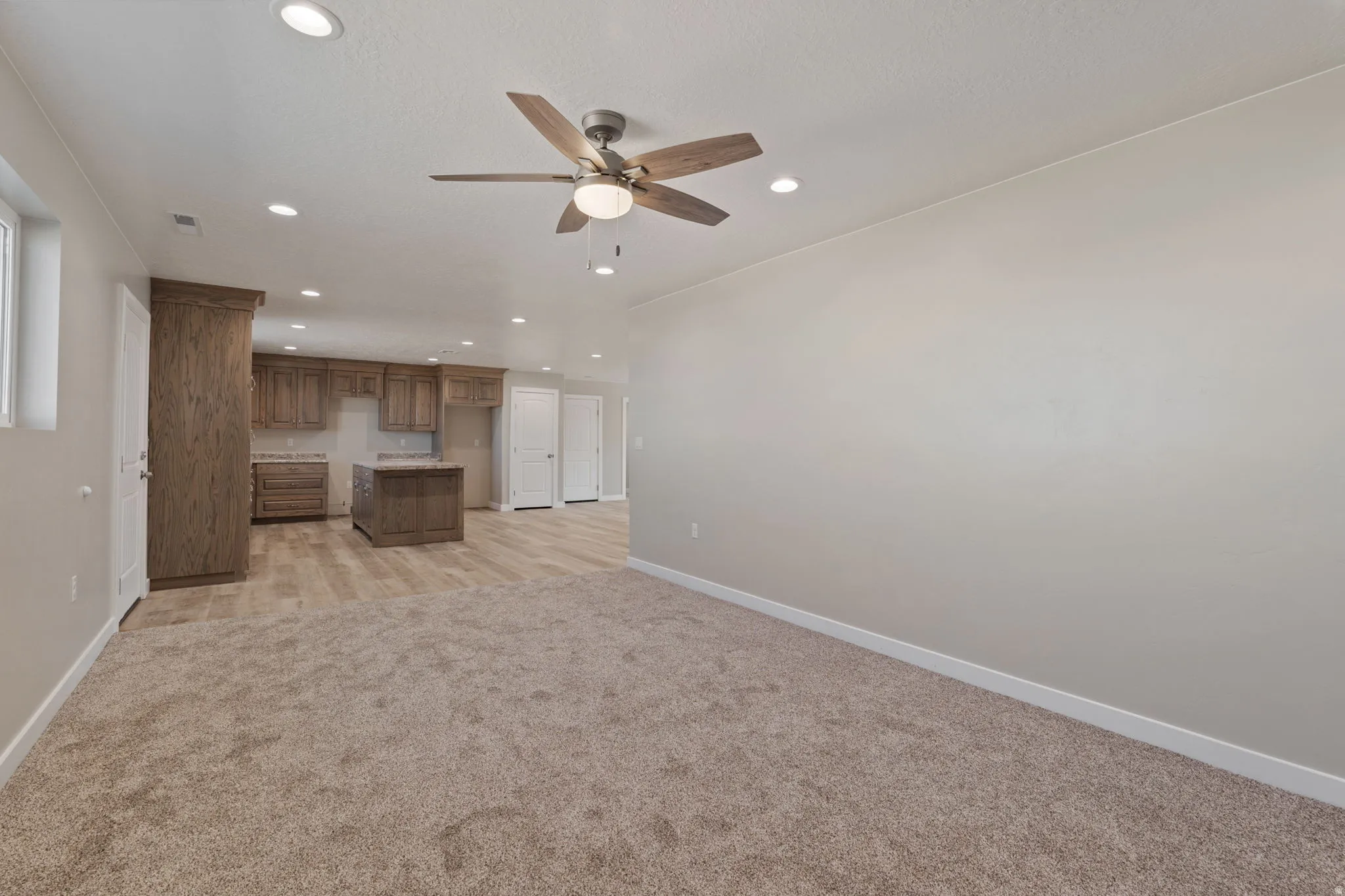 iving room with a ceiling fan, recessed lighting, and light carpet