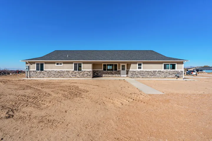 View of front facade with stone siding, stucco siding, and covered porch