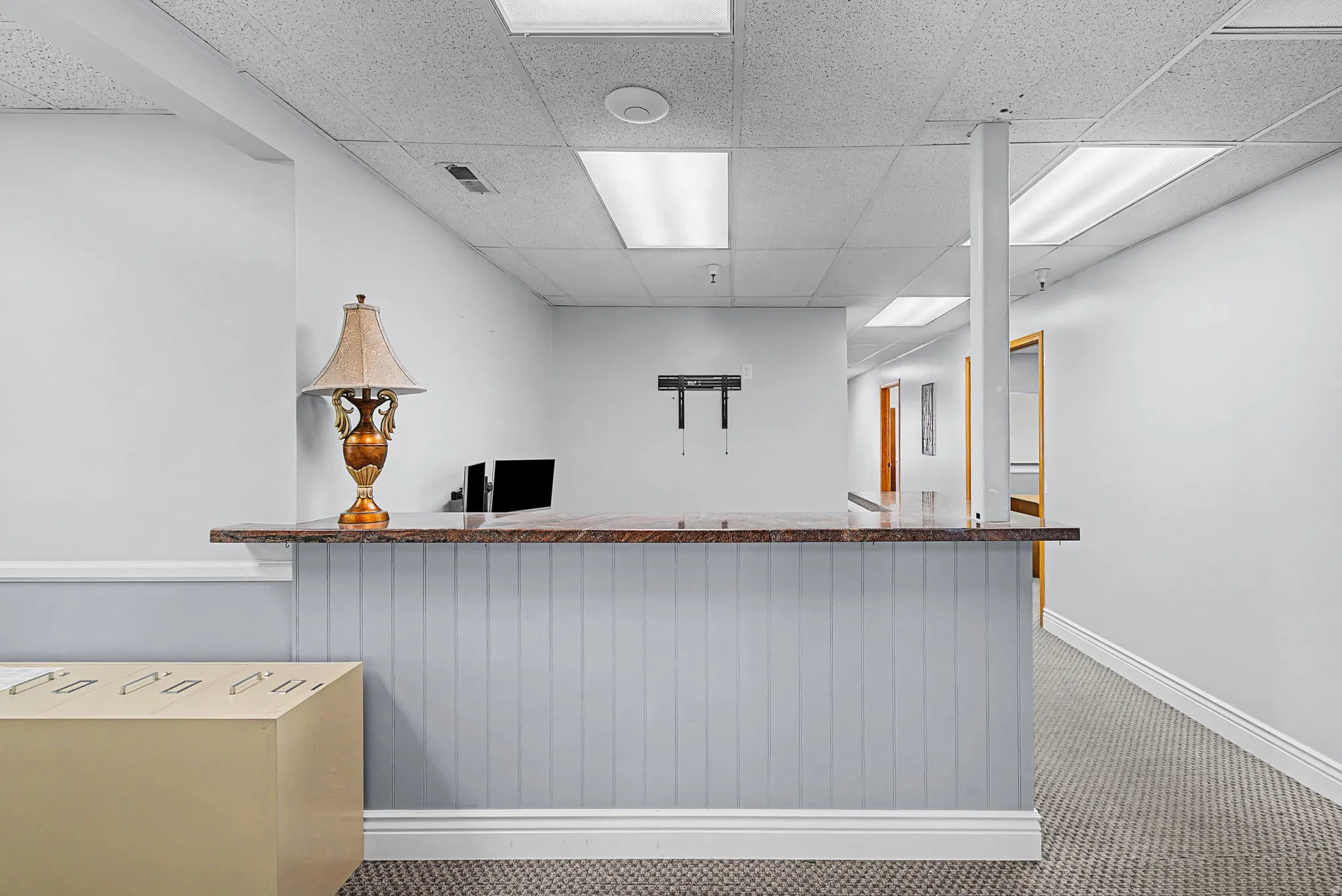 Reception featuring a drop ceiling and a community bar