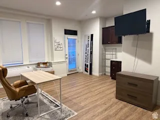 Office with light wood-style floors and recessed lighting