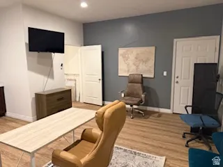 Office area with light wood-style flooring and recessed lighting