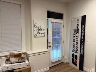 Doorway to outside with wood finished floors and baseboards