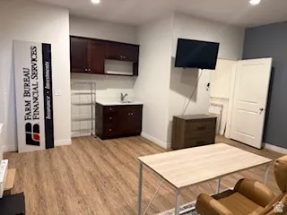 Living area with light wood-type flooring and recessed lighting